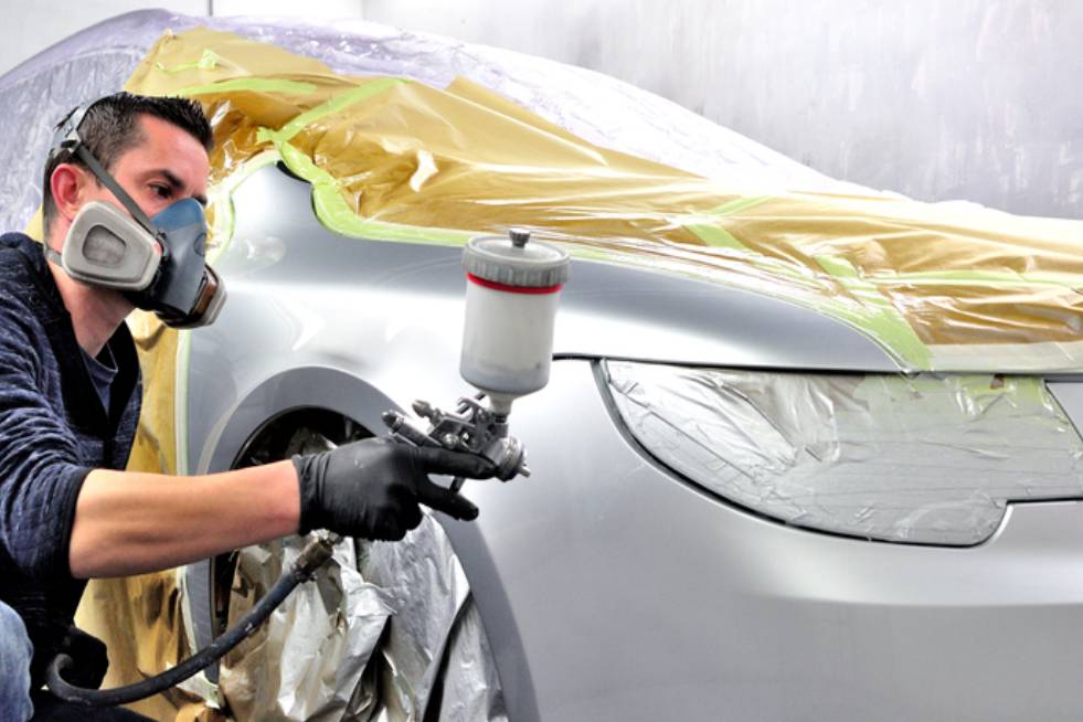 man spray painting a car